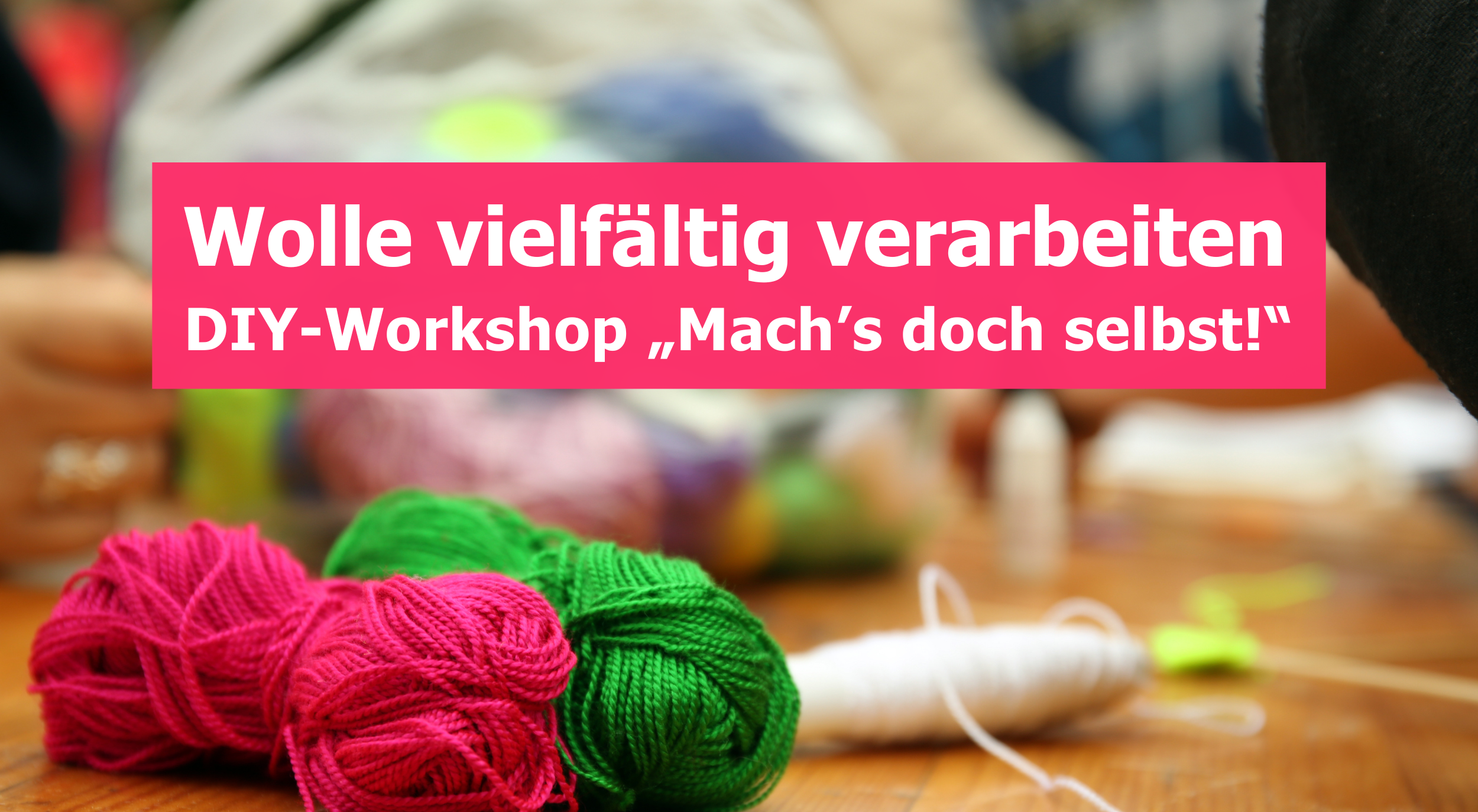 Das Bild zeigt eine Nahaufnahme von Garnknäueln in leuchtenden Farben (Pink, Grün, Weiß) auf einer Holzoberfläche. Darüber befindet sich ein rosafarbenes Textfeld mit der Aufschrift „Wolle vielfältig verarbeiten DIY-Workshop „Mach's doch selbst!"“. Der Hintergrund ist unscharf und deutet auf eine Bastel- oder Werkstattumgebung hin.