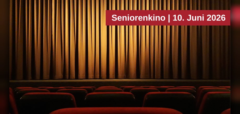 Seniorenkino am 10. Juni 2026 Das Bild zeigt einen Kinosaal mit roten Sitzen im Vordergrund und einem geschlossenen goldenen Vorhang im Hintergrund. Über dem Vorhang befindet sich ein roter Balken mit der weißen Aufschrift "Seniorenkino | 10. Juni 2026"